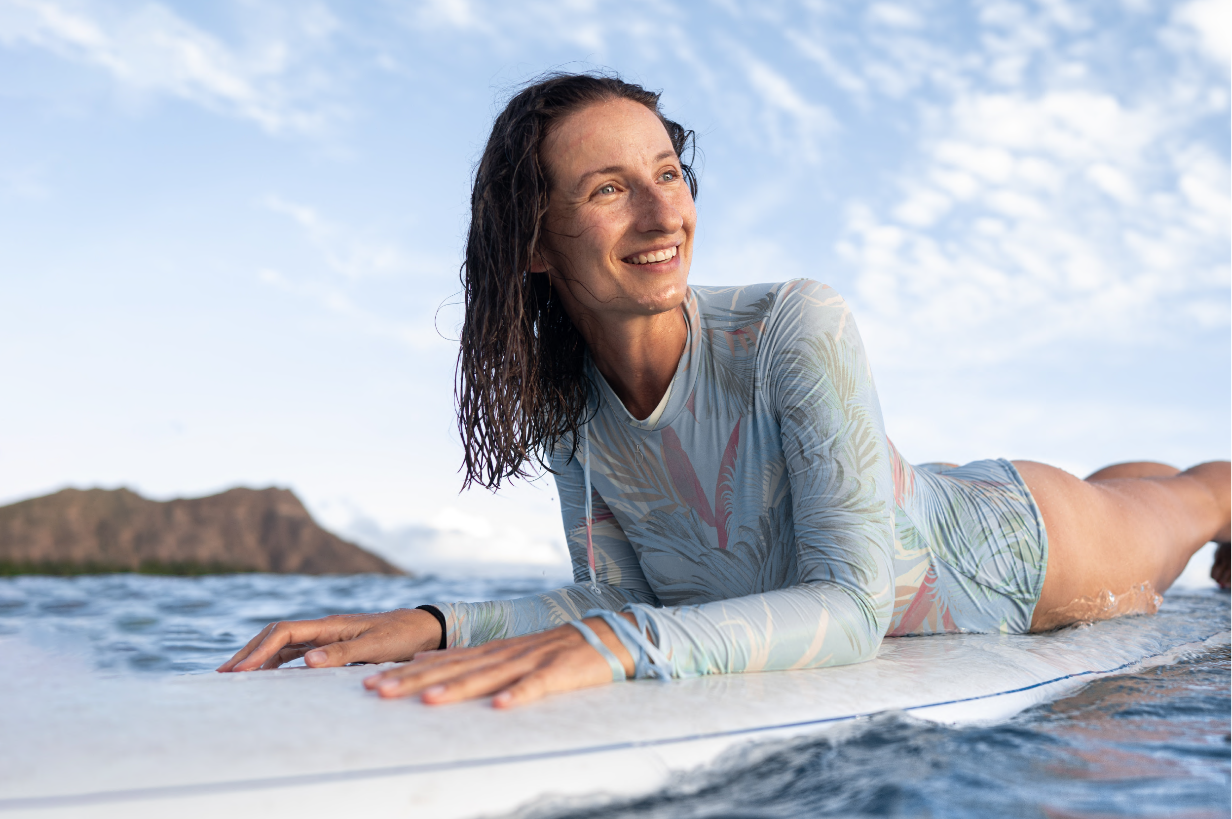 Woman smiling on a surf board in the ocean